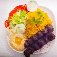 Beef Kabob Plate · Two grilled beef kabob skewers, served with yellow rice, salad, and hummus.