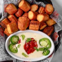 Pretzel Bites · Soft and airy deep-fried pretzel bites, served with a generous portion of queso dipping sauc...