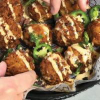Ranchero Tots · Oversized bacon & cheese stuffed tater tots served over chipotle ranch. Topped with fresh ja...