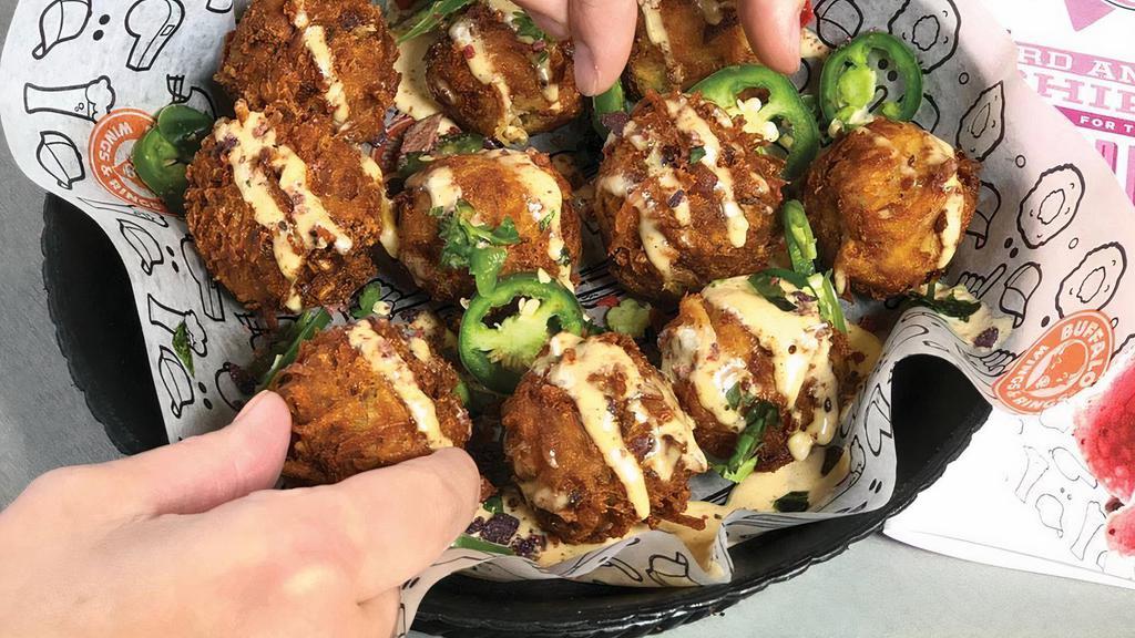 Ranchero Tots · Oversized bacon & cheese stuffed tater tots served over chipotle ranch. Topped with fresh jalapeños cilantro and chipotle ranch.
