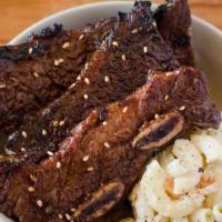 Kalbi Short Ribs · Marinated in sweet sesame soy, garlic, ginger and flamed grilled, includes rice and one choi...