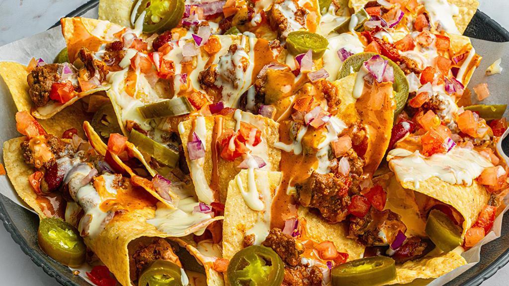 Nachos · A bed of crisp tortilla chips is loaded with house chili and queso, drizzled in ancho chile sauce, and topped with jalapenos, diced tomatoes, red onions and sour cream. (1270 cal.)