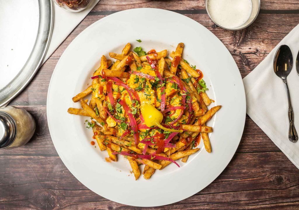 Muddy Paneer Butter Fries · Seasoned fries, farmers cheese, Indian spiced creamed butter gravy, pickled onions, cilantro, sriracha drizzle, paired with chili pepper.