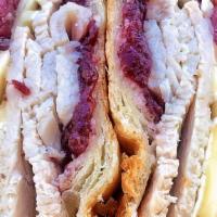 Turkey Brie Sandwich · Oven-roasted turkey breast, melted brie cheese, cranberry relish on a warm croissant and ser...
