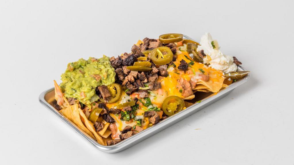 Nachos Volcano · Corn tortilla chips with melted jack and cheddar cheese, refried beans, Pico de gallo, sour cream, guacamole and jalapenos.