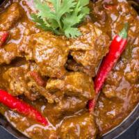 The Lamb Curry · Savory lamb with tomatoes and onions cooked with spices for a rich, hearty dish.