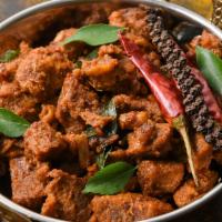 The Goat Curry · Juicy goat with tomatoes and onions cooked with spices for a rich, hearty dish.