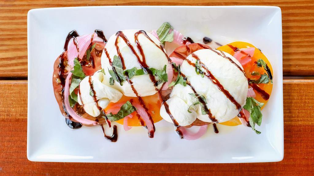 Hand Tied Burrata Cheese · -Served over heirloom tomatoes with pickled onion, fresh basil, balsamic reduction and EVOO.