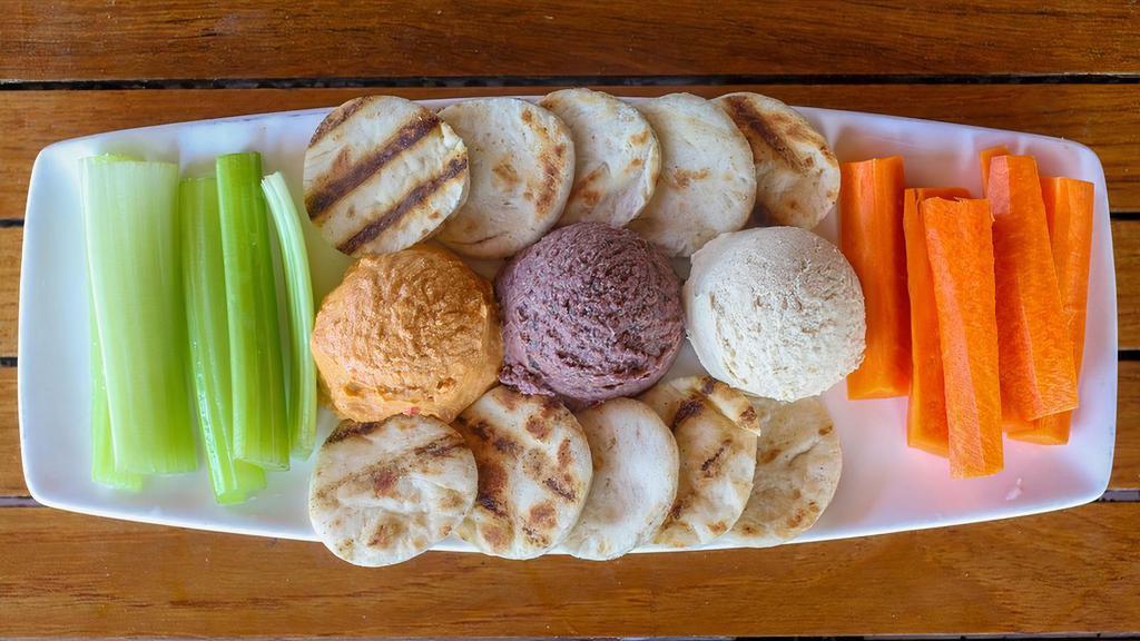 Hummus Trio Dip · Roasted garlic, roasted red pepper, and black olive hummus dip. Served with flatbread, celery, and carrot sticks.