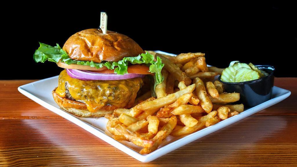 Triple T'S Cheeseburger  · (10 oz) Freshly ground burger topped with melted Cheddar, tomato, red onion, and lettuce with fries.