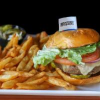 Impossible Meatless Burger · Impossible burger, topped with pepper Jack cheese, onions, pickles, lettuce, tomato, and a m...