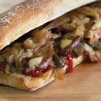 Sausage, Peppers & Onions Hero · Sliced vegan bratwurst, sautéed peppers and onions and cheese sauce on a toasted long roll.
