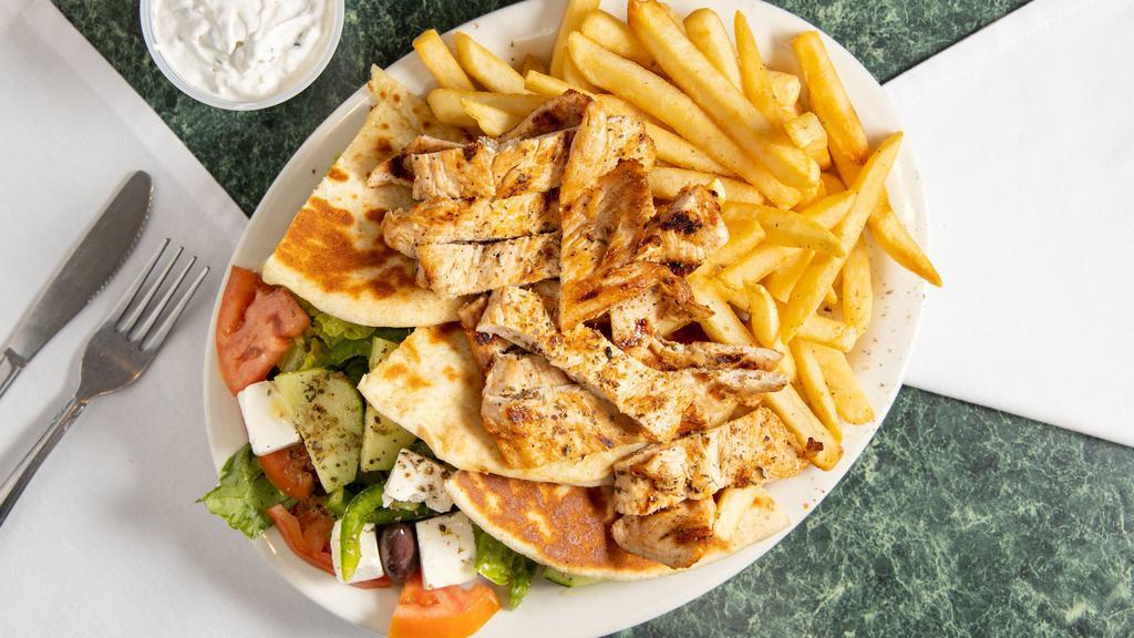 Chicken Souvlaki Platter · Greek salad with grill chicken and french fries. Pita and tzatziki sauce on the side.