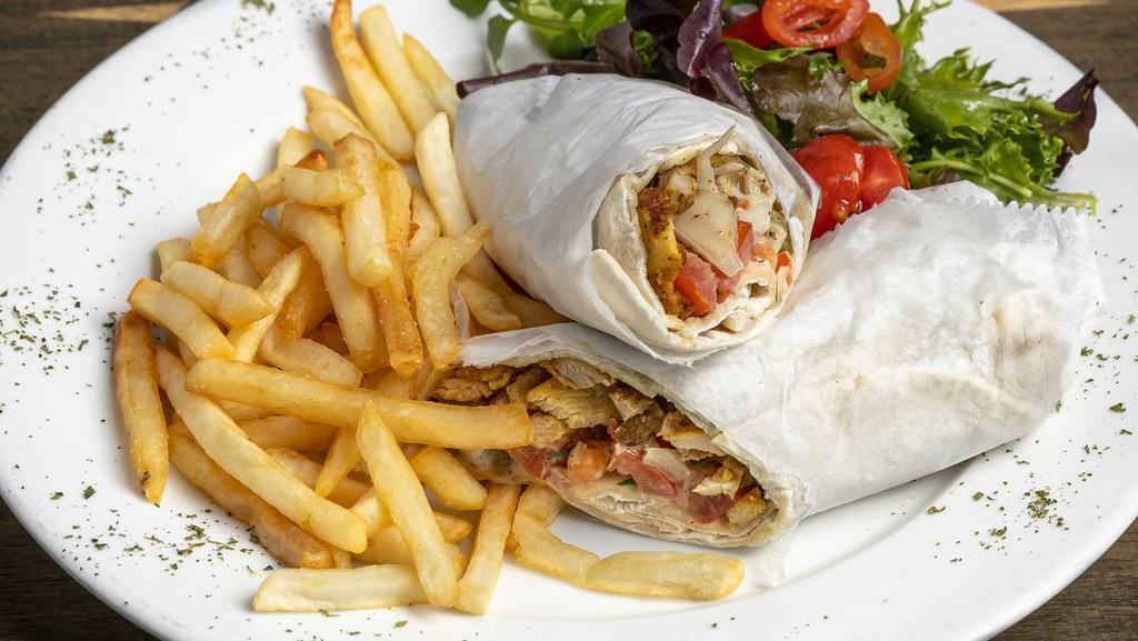 Chicken Shawarma · Strips of marinated chicken thighs with tahini sauce and onion, tomato, parsley & pickles served with mixed greens and fries