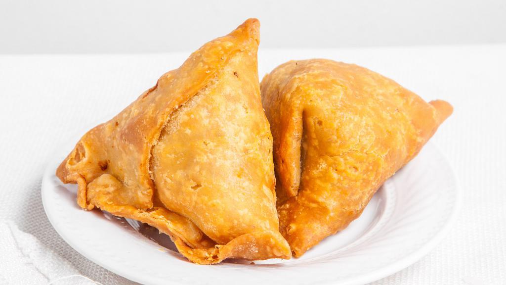 Vegetable Samosa (2 Pieces) · Golden crispy triangle pastry filled with mildly spiced potatoes & peas.