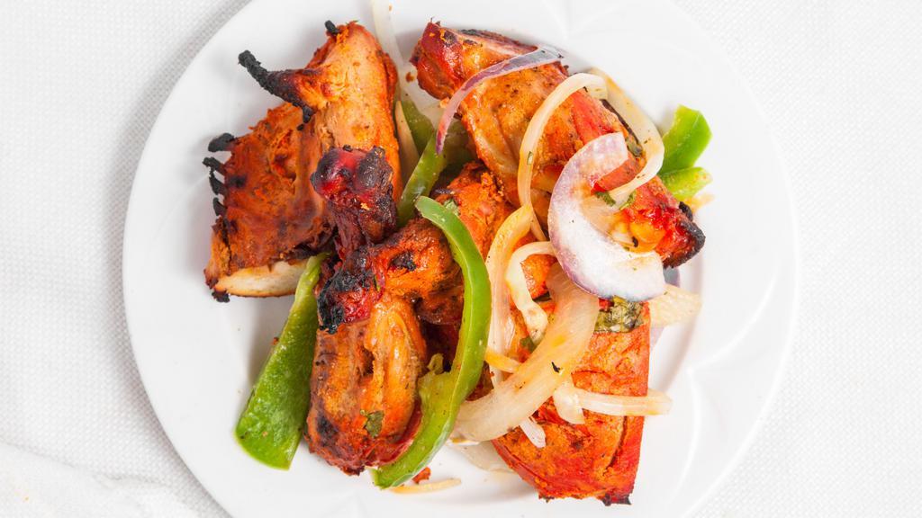 Tandoori Chicken · Served on a bed of grilled onions bell peppers and lemon mint and tamarind chutney. dishes cooked to perfection in a traditional tandoor.