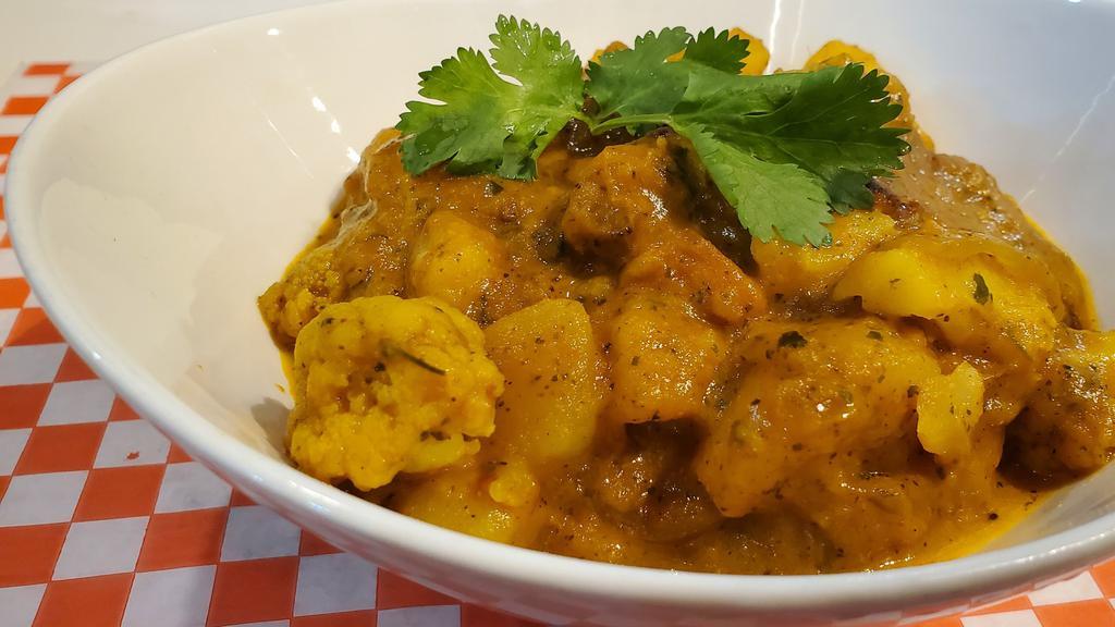 Aloo Gobi · Vegetarian. Cauliflower florets, potatoes cooked with onions, tomatoes, flavored with curry leaves and spices.