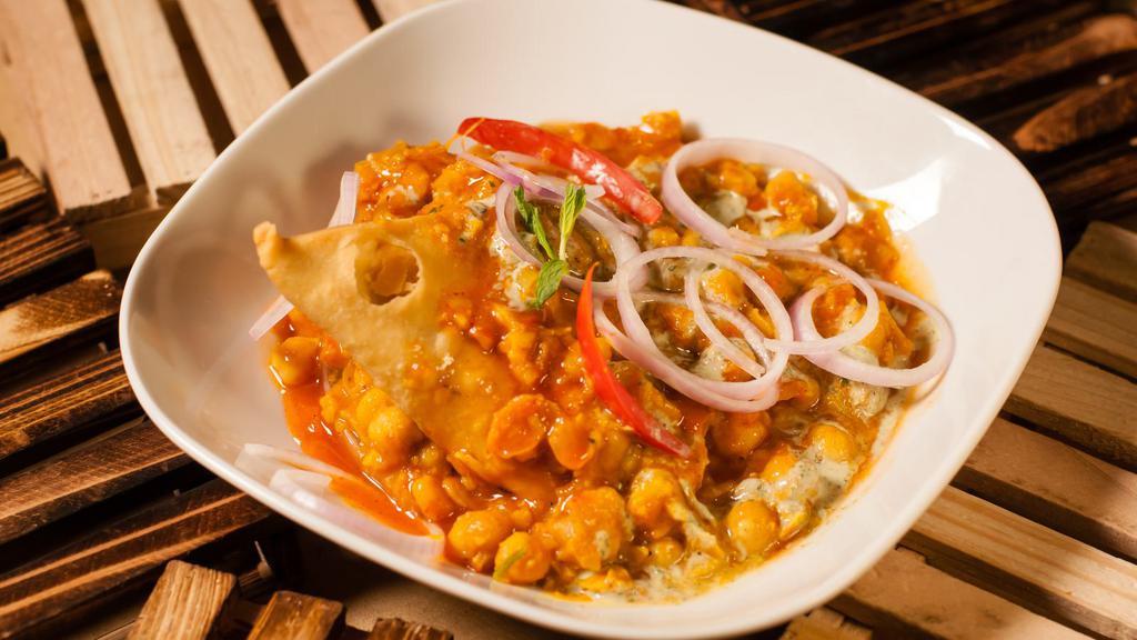 Vegan Samosa Chaat · Samosa topped with date sauce and chickpeas.