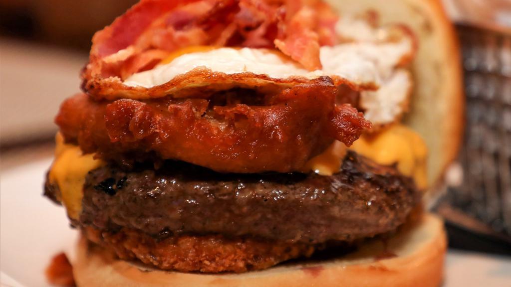 Hangover Burger · Certified Angus beef, hash brown, American cheese, bacon, onion ring, sunny side up egg.