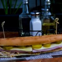 Sandwich Cubano  · a delicious combination of French bread with pernil with pickles, ham and Swiss cheese toppe...