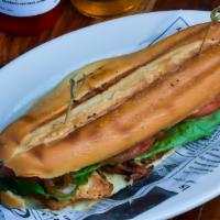 Sandwich De Pechuga De Pollo · a tasty combination of our chicken breast with caramelized onions, tomatoes and lettuce on a...