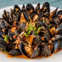 Steamed Mussels · Mussels sautéed with fresh tomatoes, scallions, fresh herbs, feta cheese, flambeed with ouzo.