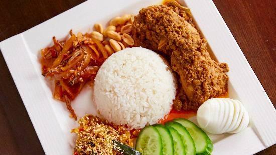 Nasi Lemak · Hot & spicy. Coconut rice with vegetable pickled, anchovy, curry chicken, hard-boiled egg, peanut, cucumber & sesame seed, slightly spicy.