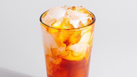 Thai Iced Tea · A blend of black tea, vanilla, and cinnamon poured over ice and topped with half & half.