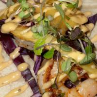 Shrimp-Lime Taco · Marinated shrimp, chipotle, cabbage, grilled pineapple, lime and drizzle of tartare sauce.