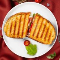 Monte Cristo Panini · Panini filled with turkey, ham, Swiss cheese, cheddar cheese, lettuce, tomato and honey must...