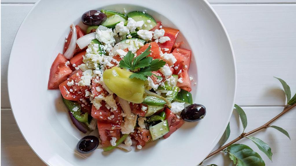 Horiatiki Salad · Vine ripe tomatoes, cucumber, red onion, peppers, olives, and Arahova feta.