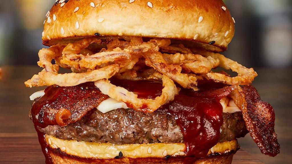 ‘Cue Bacon Cheeseburger* · Melted white American cheese, peppered bacon, crispy onion tanglers and sweet ‘n’ tangy barbecue sauce.