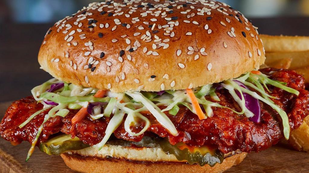 Nashville Hot Chicken Sandwich · Hand-breaded chicken breast tossed in Nashville Hot sauce, crunchy sweet celery coleslaw, dill pickles, toasted black and white sesame seed bun.