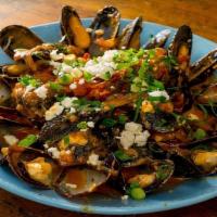 Mussels Ahnista · Gluten free. Sautéed in light tomato sauce with herbs, ouzo, and sprinkledo with feta cheese.