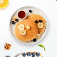 Berry Banana Pancakes · Banana and berries pancakes with butter and maple syrup.