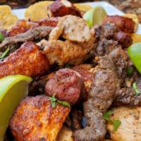 Tipico Picadera · a plate full of grilled chicken, grilled steak, fried cheese, Dominican sausage, tostones an...