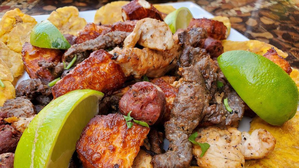 Tipico Picadera · a plate full of grilled chicken, grilled steak, fried cheese, Dominican sausage, tostones and French fries ready to be shared.