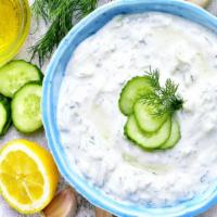 Tzatziki · Strained yogurt prepared with minced cucumbers, garlic, salt, and olive oil.