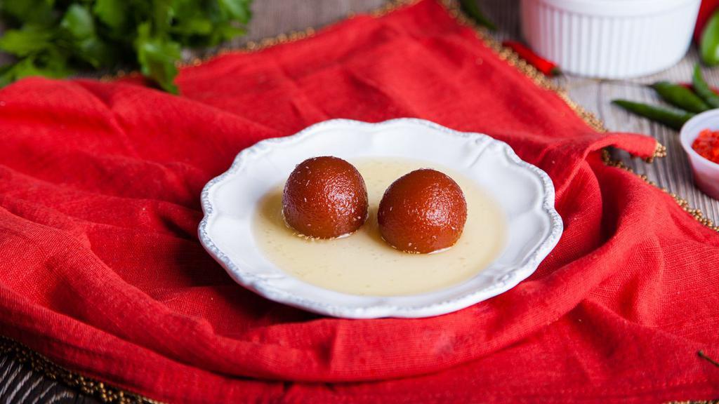 Gulab Jamun · A classic sweet made of fried balls of dough from milk solids and soaked in a cardamom and saffron syrup.