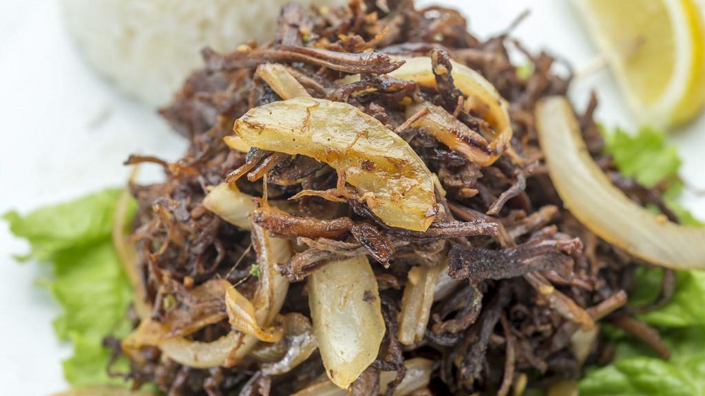 Vaca Frita · Served with pan seared shredded skirt steak, fresh mojo, onions and lime.