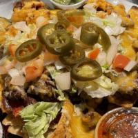 South Of The Border Nachos · Tortillas topped with chico beans, steak, and chicken with cheese, pico de gallo, sour cream...