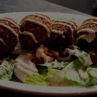 Falafel Wrap Deluxe · Vegetable patties deep fried, drizzled with tahini sauce topped with tomatoes, radishes, and...