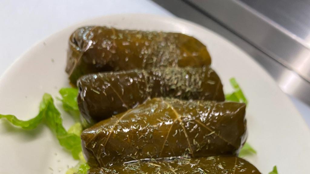 Dolmades (6) · Vegan. Rice & herb stuffed grape leaves, served with a side of tzatziki.