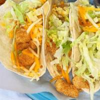 Fish Tacos · Three tacos with lettuce and pico de gallo.