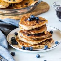 Blueberry Pancakes · Stack of fluffy blueberry packed pancakes served with butter and syrup.