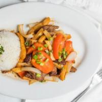 Lomo Saltado · Strips of steak stir fried with tomato, onion, and garlic, tossed with fries and served with...