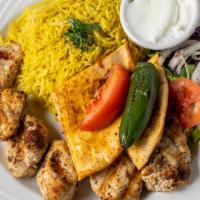 Organic Chicken Kebab · Two skewers of grilled marinated chicken cubes with rice.