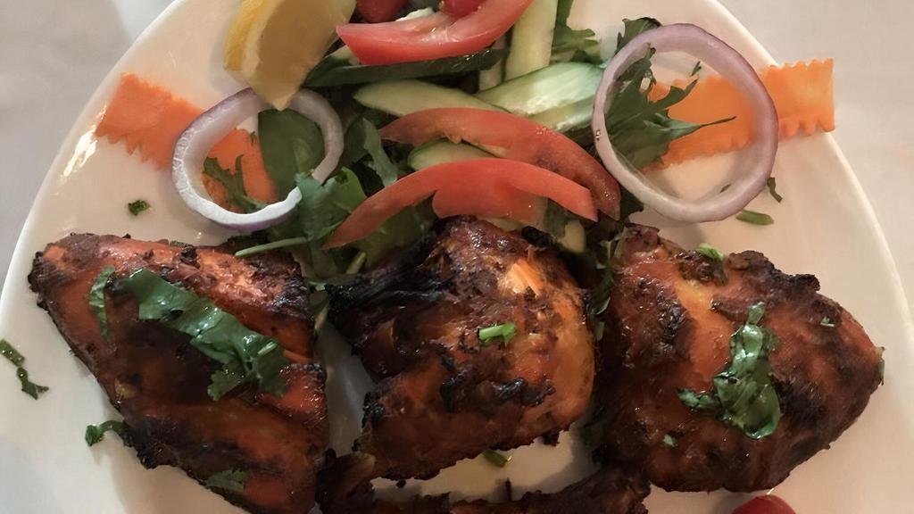 Tandoori Chicken · Tender pieces of chicken on the bone marinated with spices, herbs, ginger, and garlic paste and grilled in tandoor.