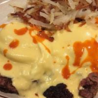 Corned Beef Hash Ala Madison · Two poached eggs with corned beef hash topped with hollandaise sauce.