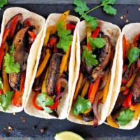 Veggie Tacos · Aromatic vegetarian tacos filled with black beans, roasted vegetables, and a delicious cream...